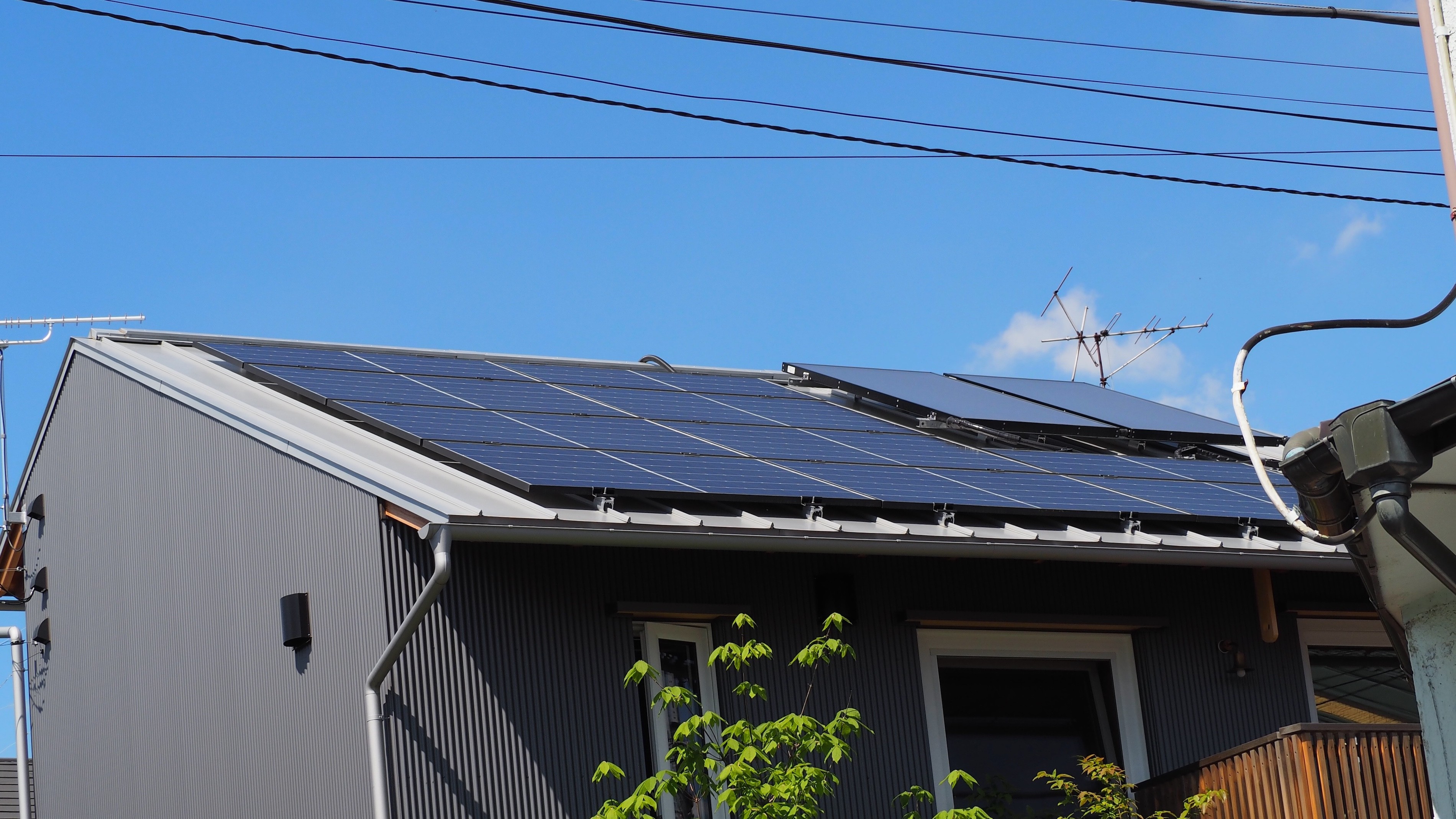 外観事例：屋根には太陽光発電と太陽熱利用エコキュートのパネルが載っています（オフグリッドな我が家）