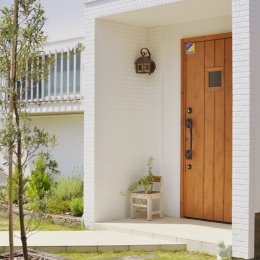 川崎市S様邸 ～子供が走り回る家～-木のドアと白い外壁がまぶしいエントランス。