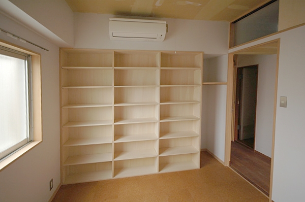 ベッドルーム事例：寝室に作った壁一面の本棚と廊下の上の収納（家具で仕切りをつくったマンションリノベ）