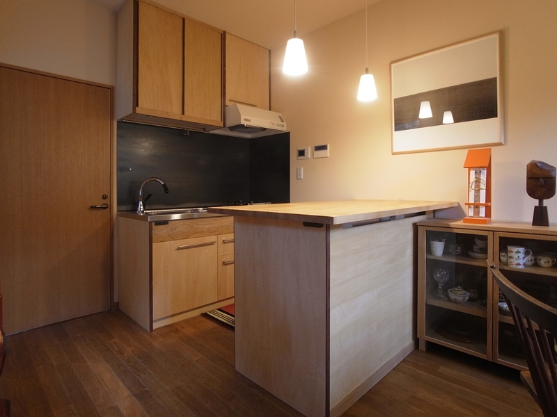 キッチン事例：キッチン／手前の作業台に冷蔵庫が収まる（ローコストリノベーション　　無機質空間から木質空間へ）