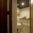 古さを活かして壁はアーチに。60年代や70年代の住まいのようなヴィンテージ風の家の写真 トイレ