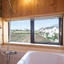 緑豊かな庭を背景に「甲板のある家」の写真 光の差し込む浴室