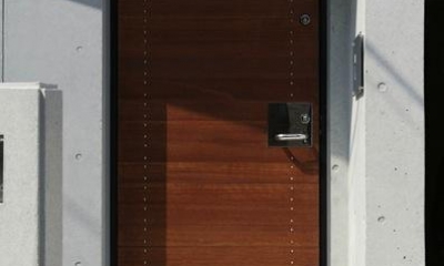 コンクリート壁に木製玄関ドア｜『I・K邸』コンパクト＆機能満載の住まい
