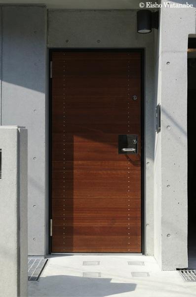 外観事例：コンクリート壁に木製玄関ドア（『I・K邸』コンパクト＆機能満載の住まい）