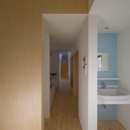 『囲む家』様々な表情のある、楽しく温かな住まいの写真 キッチン・壁面ブルーの洗面室