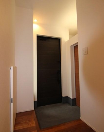 黒いドアがアクセントの玄関 (『LX2 house』2つのリビングがある共働き・子育て世帯の理想の家)