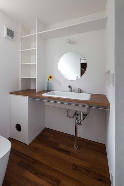 丸鏡のシンプルな洗面スペース (『よみうりランド前の家』仕事と主婦業の両立がしやすい住まい)