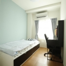 K邸・小さな個室と大きなリビング、心地のよい暮らし方の写真 ブルーのアクセントクロスが爽やかな寝室